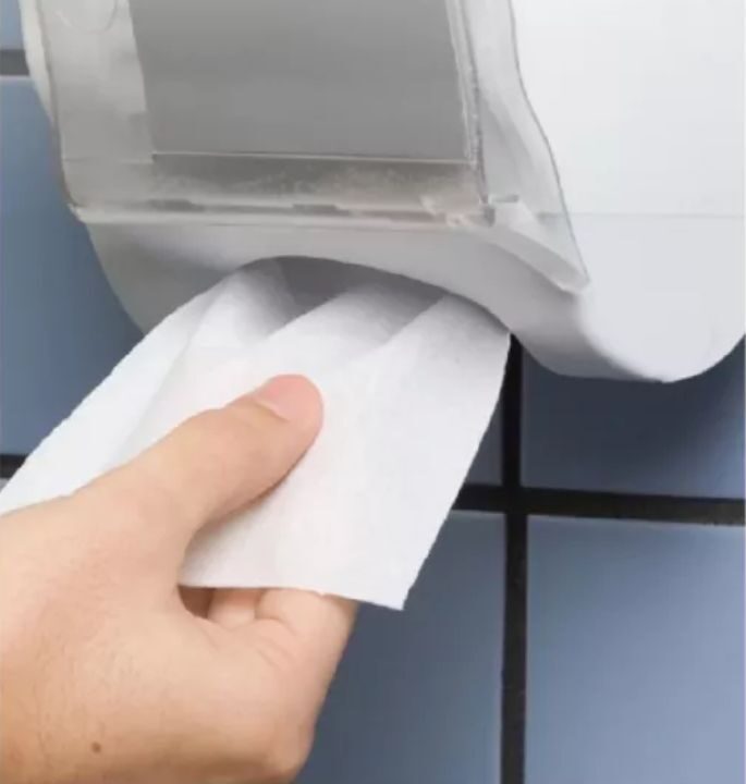 pessoa pegando papel higiênico interfolhado no dispenser