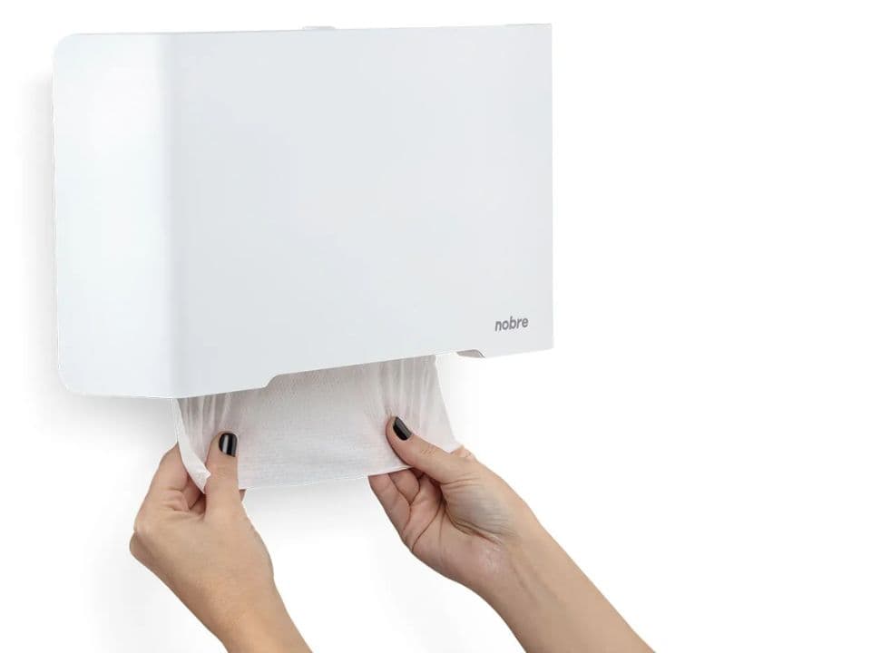 pessoa pegando papel higiênico interfolhado cai cai no dispenser
